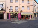 un immeuble qui comporte de nombreuses fenêtres et sur lequel est accrochée une enseigne sur le côté