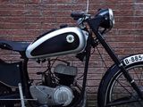 a black and white motorcycle parked in front of a brick wall
