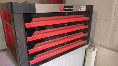 une boîte à outils rouge et noire posée sur un radiateur