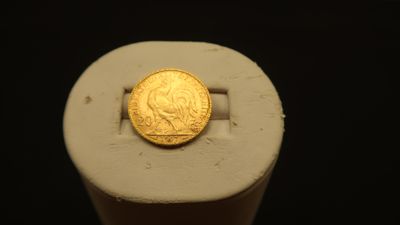 a gold coin sitting on top of a white object