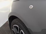 the rear end of a silver car with a black rim