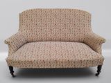 un fauteuil rembourré dont le dossier et les accoudoirs sont recouverts d'un tissu à motifs