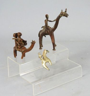 three figurines of people riding horses and a dog