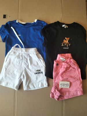 trois shorts et un t-shirt posés sur une boîte en carton