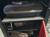 a printer sitting on top of a shelf in a room