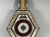 une photo d'une horloge murale décorative accrochée à un mur blanc