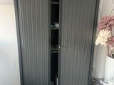 a tall cabinet with a door open in a room