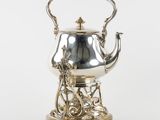 une théière ancienne en argent, munie d'une anse et d'un support