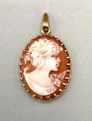 un pendentif plaqué or représente le profil d'une femme