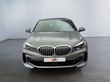 the front view of a silver bmw car in a showroom