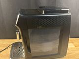 a black toaster sitting on top of a wooden table next to a wall