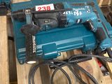 deux outils électriques posés sur une palette dans un entrepôt