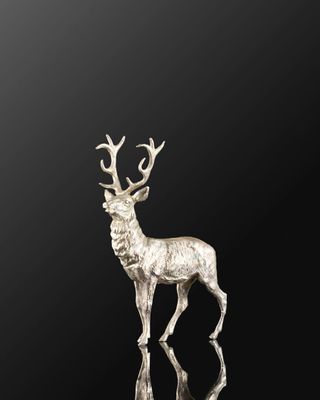une figurine de cerf en argent sur fond noir