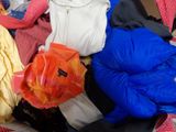 a pile of clothes sitting on top of a bed