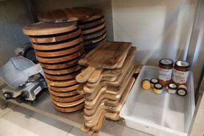 une pile de plateaux en bois posés sur une étagère dans une cuisine