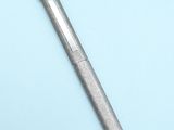 a metal pen that is laying on a blue surface