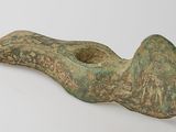 an old bronze pipe with a green patt on it