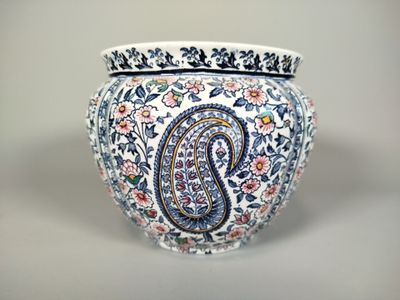 un vase orné d'un motif paisley, posé sur une table