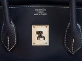 the handle of a black handbag with a ring on it