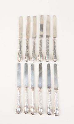 six silverwares on a white table with a knife