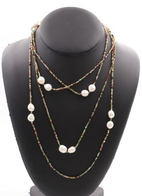 a close up of a necklace on a mannequin with pearls