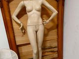 a female mannequin standing in front of a wooden door