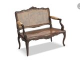 a wooden bench with a wicker seat on it