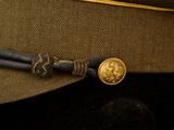 a brown hat with a gold button on it