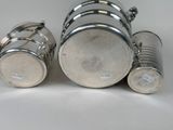 two silver cups sitting next to each other on a white surface