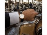 a man wearing a watch on his wrist while riding a scooter