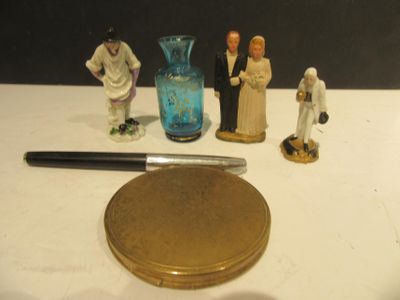 several figurines are sitting on a table next to a knife