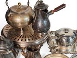 a lot of silver teapots and dishes on the table