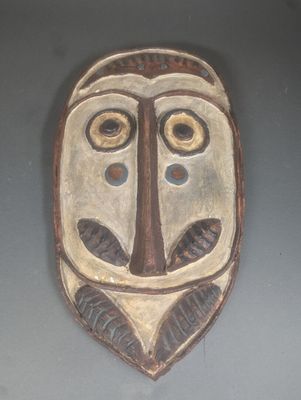un masque en bois accroché au mur