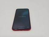 the back of a red cell phone sitting on top of a white table