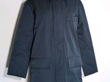 Le manteau est bleu et comporte deux poches à l'avant.
