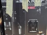 two boxes of krups coffee machines sitting on top of a wooden table