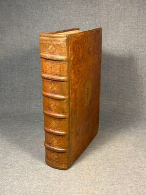 an old book sitting on top of a table next to a gray background