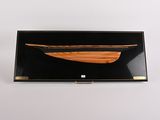 pochette noire et dorée ornée d'un bateau en bois sur le devant