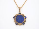 un pendentif en or et lapis-lazuli orné d'une pierre bleue