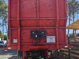 un camion-benne rouge garé sur le bord de la route