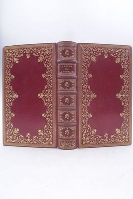 un livre rouge ouvert sur une surface blanche