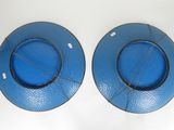 two blue plates on a white table with a white background