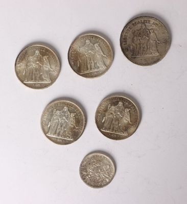 six different british coins are arranged in a row on a white surface