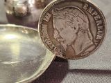 a silver plate with a coin on it next to a silver cup