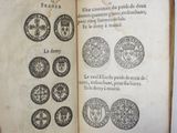 an open book with a bunch of coins on it