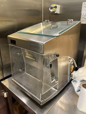 un plan de travail en acier inoxydable avec un évier en verre et un rouleau de papier toilette posé dessus