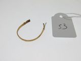 une paire de boucles d'oreilles en or en forme d'anneau, avec son étiquette de prix, posée sur une table blanche