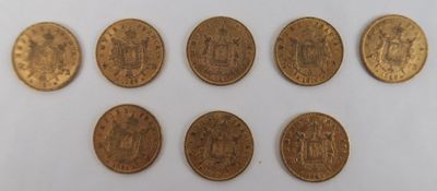 a group of six gold coins sitting on top of a white surface