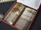 a box of silverware sitting on a table next to a fork and knife