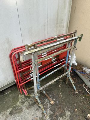a red metal bench sitting next to a white wall